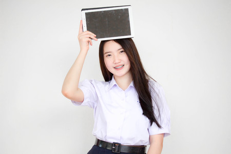 Portrait of thai high school student uniform beautiful girl using her tablet.の写真素材