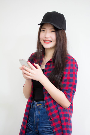 Portrait of thai china teen beautiful girl using her phone and smileの写真素材