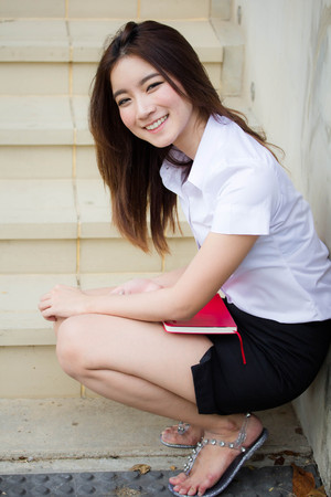 Portrait of thai adult student university uniform beautiful girl relax and smileの写真素材