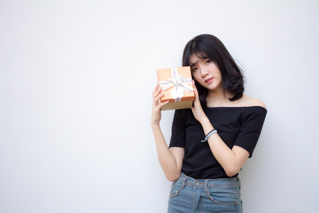 Portrait of thai vietnam teen beautiful girl hold gift box in handsの写真素材