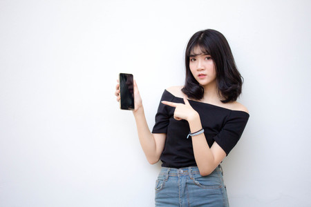 Portrait of thai vietnam teen beautiful girl using her phone and smileの写真素材