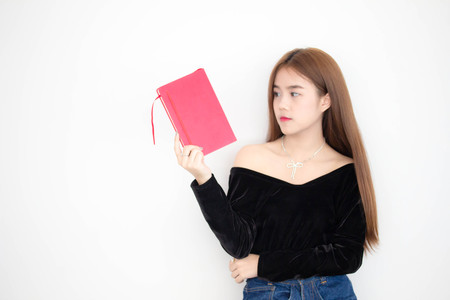 Portrait of thai adult beautiful girl reading red bookの写真素材