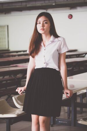 Portrait of thai adult student university uniform beautiful girl relax and smileの写真素材