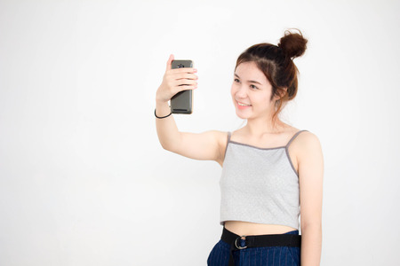 Portrait of thai adult beautiful girl using her smart phone Selfieの写真素材