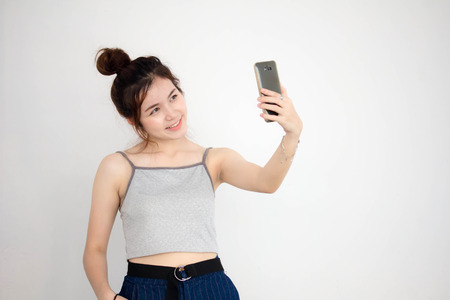 Portrait of thai adult beautiful girl using her smart phone Selfieの写真素材