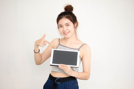 Portrait of thai adult beautiful girl show her tablet.の写真素材