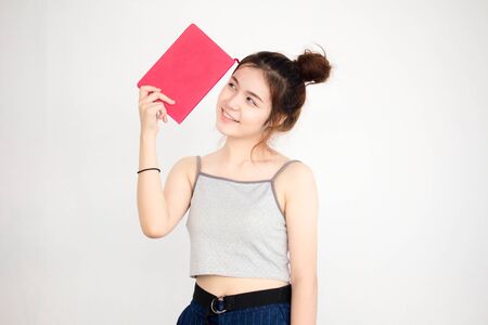 Portrait of thai adult beautiful girl read red bookの写真素材