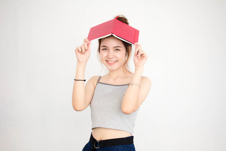Portrait of thai adult beautiful girl read red bookの写真素材