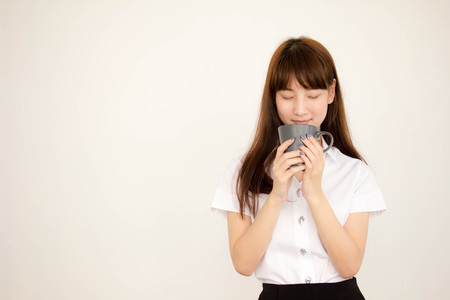 Portrait of thai adult student university uniform beautiful drinking coffeeの写真素材