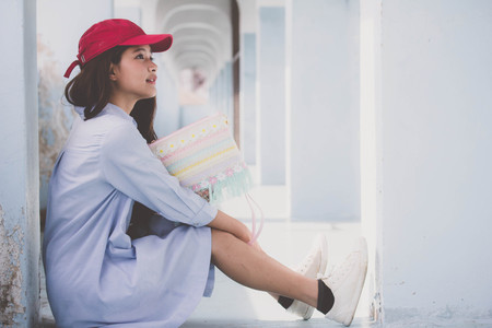 Portrait of thai teen beautiful girl blue dress red hat happy and relaxの写真素材
