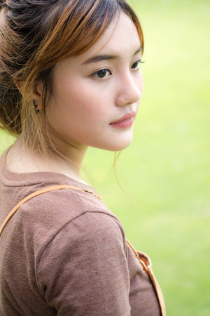 Beautiful young adult thai chinese bronze hair relax and smileの写真素材