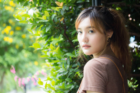 Beautiful young adult thai chinese bronze hair relax and smileの写真素材