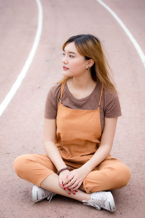 Beautiful young adult thai chinese bronze hair relax and smileの写真素材