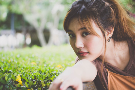 Beautiful young adult thai chinese bronze hair relax and smileの写真素材