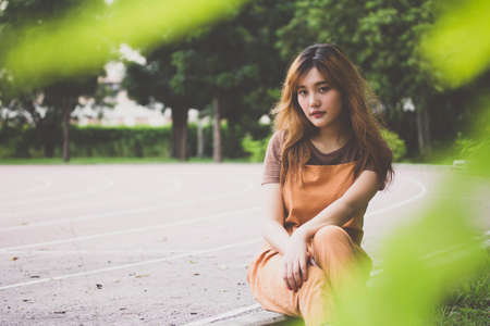 Beautiful young adult thai chinese bronze hair relax and smileの写真素材