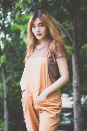 Beautiful young adult thai chinese bronze hair relax and smileの写真素材