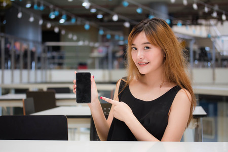 Beautiful young adult thai chinese bronze hair show her smart phone