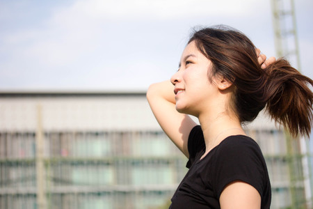 portrait of thai beautiful young adult, relaxed and smile in tennis courtの写真素材