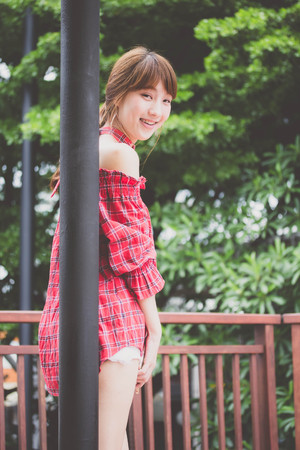 Beautiful young adult thai japanese Red Scottish Dress relax and smile in Vintage Styleの写真素材