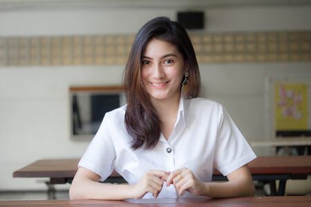 Portrait of thai adult student university uniform beautiful girl relax and smileの写真素材