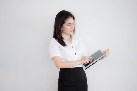 Portrait of thai adult student university uniform beautiful girl using her tablet.の写真素材