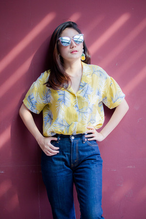 Portrait of thai yellow shirt adult beautiful girl relax and smileの写真素材