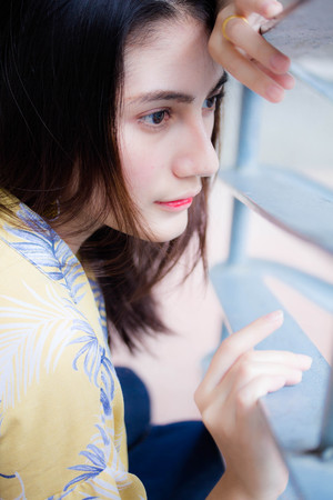 Portrait of thai yellow shirt adult beautiful girl relax and smileの写真素材