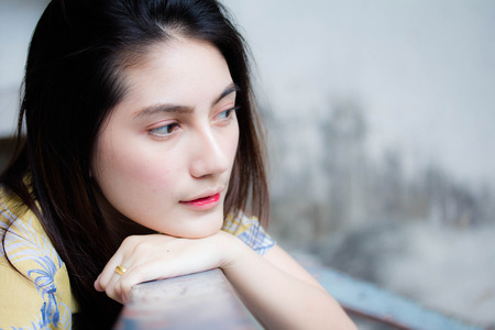 Portrait of thai yellow shirt adult beautiful girl relax and smileの写真素材