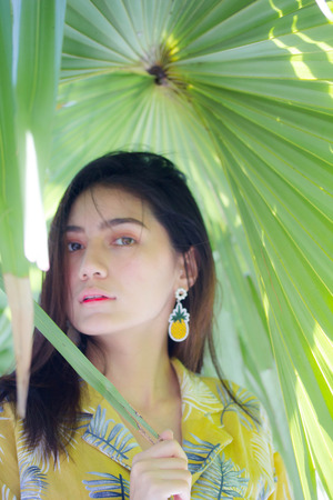 Portrait of thai yellow shirt adult beautiful girl relax and smileの写真素材