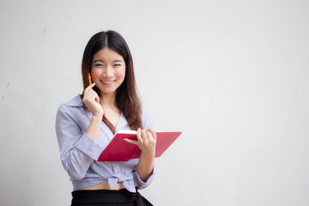 Portrait of thai adult working women reading red bookの写真素材