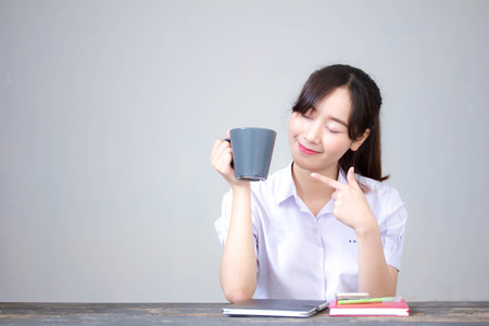 asia thai high school student uniform beautiful girl drinking coffeeの写真素材