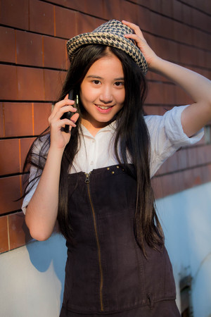Portrait of thai teen beautiful girl calling smart phoneの写真素材