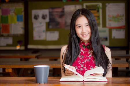 Portrait of thai teen beautiful girl in Chinese dress read a book.の写真素材