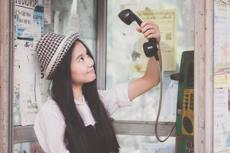 Portrait of thai teen beautiful girl using her phone and smileの写真素材