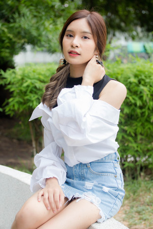 Portrait of thai Jeans skirt white shirt adult beautiful girl relax and smile