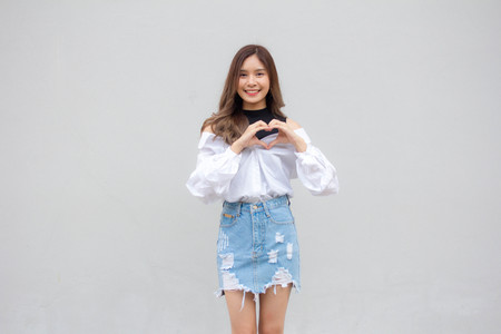 Portrait of thai Jeans skirt white shirt adult beautiful girl give heartの写真素材