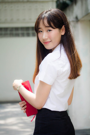 Portrait of thai adult student university uniform beautiful girl relax and smileの写真素材