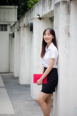 Portrait of thai adult student university uniform beautiful girl relax and smileの写真素材