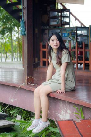 Portrait of thai china adult beautiful girl Green dress blue jeans relax and smileの写真素材