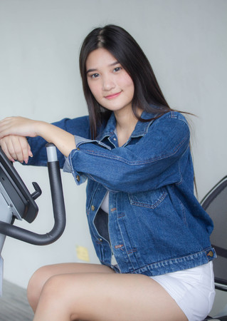 Portrait of thai adult beautiful girl blue jeans in fitness relax and smileの写真素材