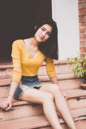 Portrait of thai Jeans skirt yellow shirt adult beautiful girl relax time, in Vintage Styleの写真素材