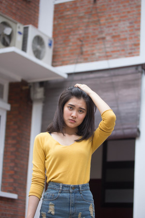 Portrait of thai Jeans skirt yellow shirt adult beautiful girl relax and smileの写真素材