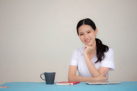 Portrait of thai adult student university uniform beautiful girl relax and smileの写真素材