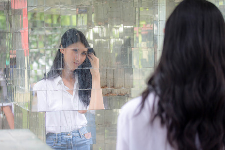Portrait of thai china adult beautiful girl White shirt blue jeans relax and smileの写真素材