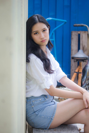 Portrait of thai china adult beautiful girl White shirt blue jeans relax and smileの写真素材