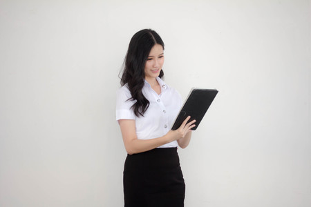 Portrait of thai adult student university uniform beautiful girl using her tablet.の写真素材