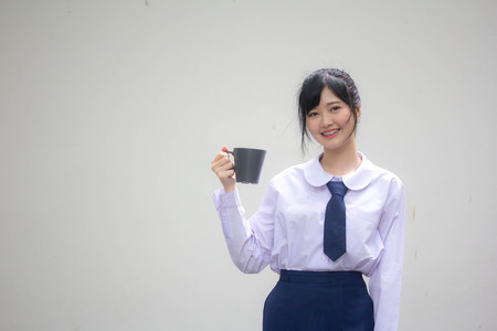 asia thai high school student uniform beautiful girl drinking hot drinkの写真素材