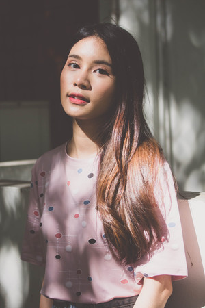 Portrait of thai adult beautiful girl pink shirt blue jeans relax and smile