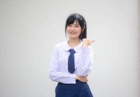 Portrait of thai high school student uniform beautiful girl pointingの写真素材