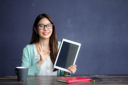 thai china adult office girl glasses white shirt show her tablet.の写真素材